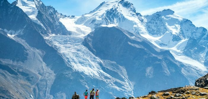 The Via Valais Trail runners in the landscape looking at the Dom, while on the Via Valais, a multi-day trail running tour connecting Verbier with Zermatt, Switzerland.